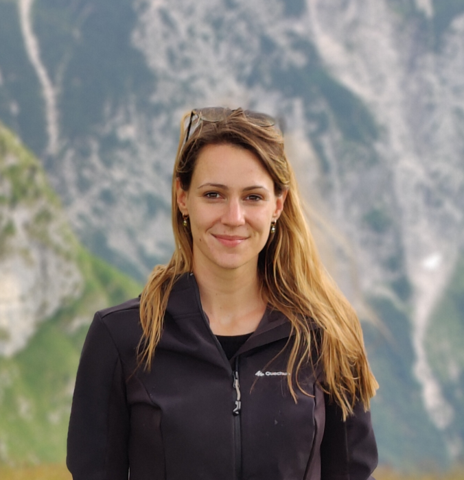 Een portretfoto van Laura met bergen op de achtergrond