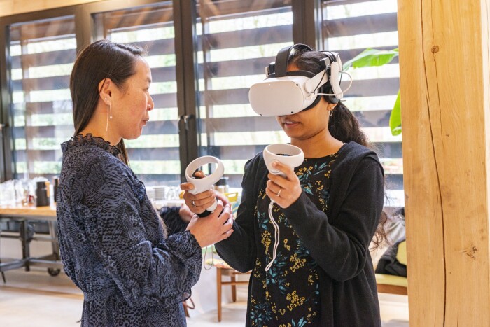 Opleidingsadviseur Tessa van Aalten ondersteunt een deelnemer met een VR-bril op