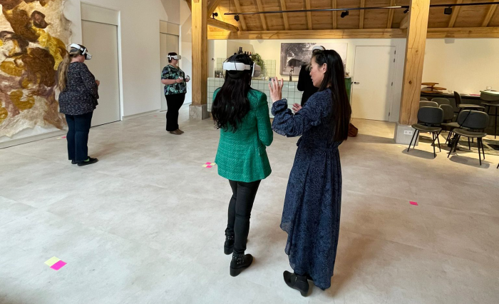 Opleidingsadviseur geeft tijdens een VR-training uitleg aan een deelnemer met een VR-bril op.